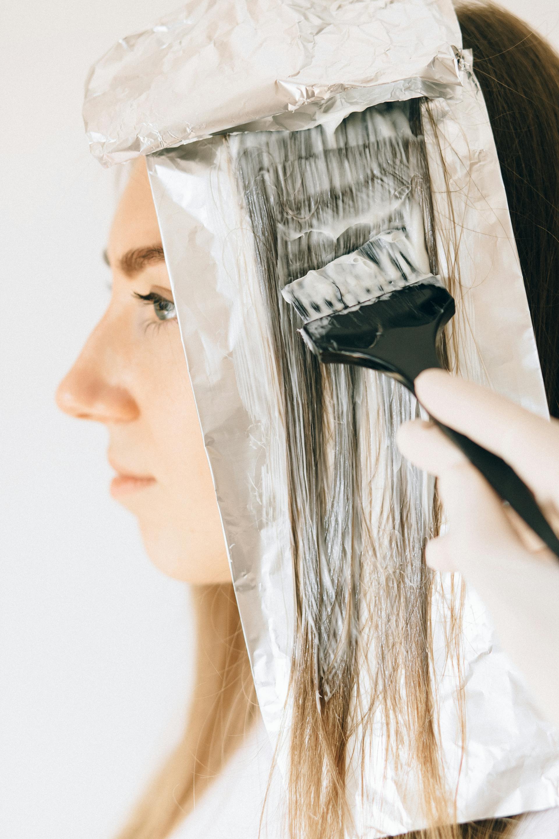 Colourist hands placing foils for a balayage